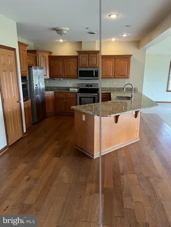 a kitchen with stainless steel appliances granite countertop a refrigerator a stove top oven a sink and dishwasher