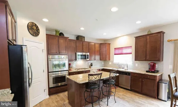 a kitchen with a refrigerator a stove a sink and a window