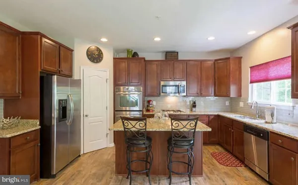 a kitchen with stainless steel appliances kitchen island granite countertop a sink and cabinets