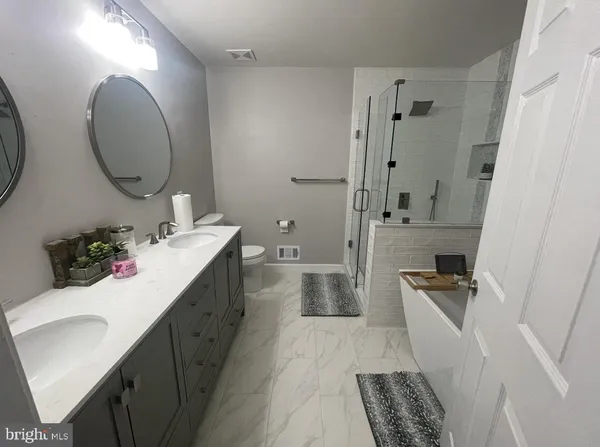 a bathroom with a sink mirror and tub
