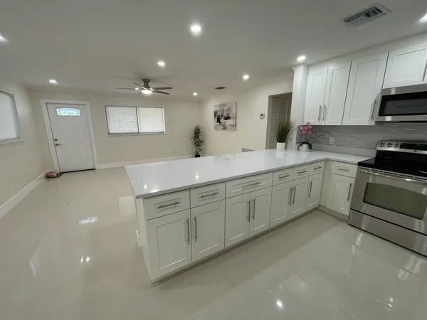 a view of kitchen with refrigerator and window