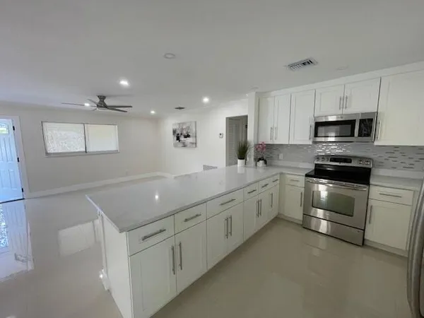 a kitchen with granite countertop a sink and white stainless steel appliances