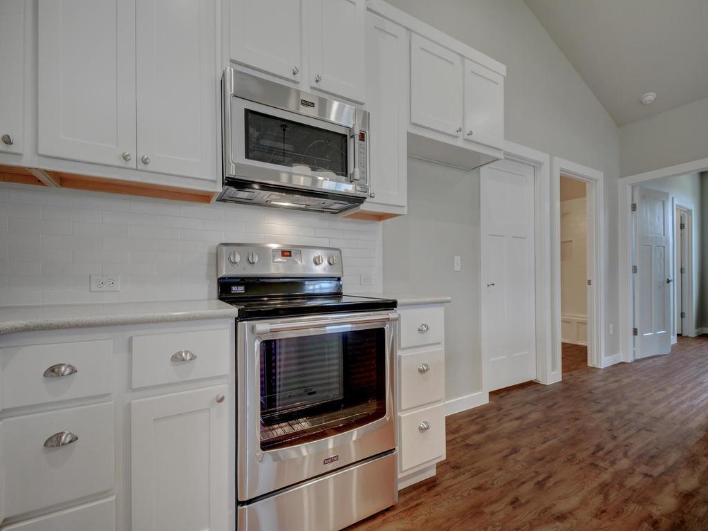 240 Rose Drive, Unit A Dripping Springs, TX 78620 - Photo 10 of 30 a kitchen with stainless steel appliances granite countertop a stove microwave and cabinets