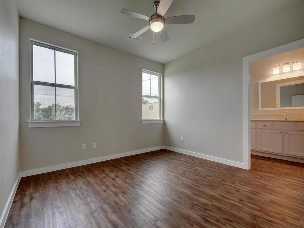 240 Rose Drive, Unit A Dripping Springs, TX 78620 - Photo 11 of 30 a view of an empty room with wooden floor and a window