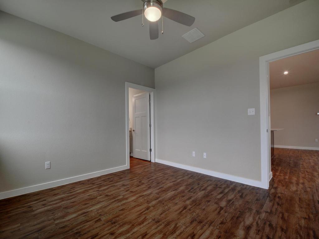 240 Rose Drive, Unit A Dripping Springs, TX 78620 - Photo 12 of 30 an empty room with wooden floor and windows
