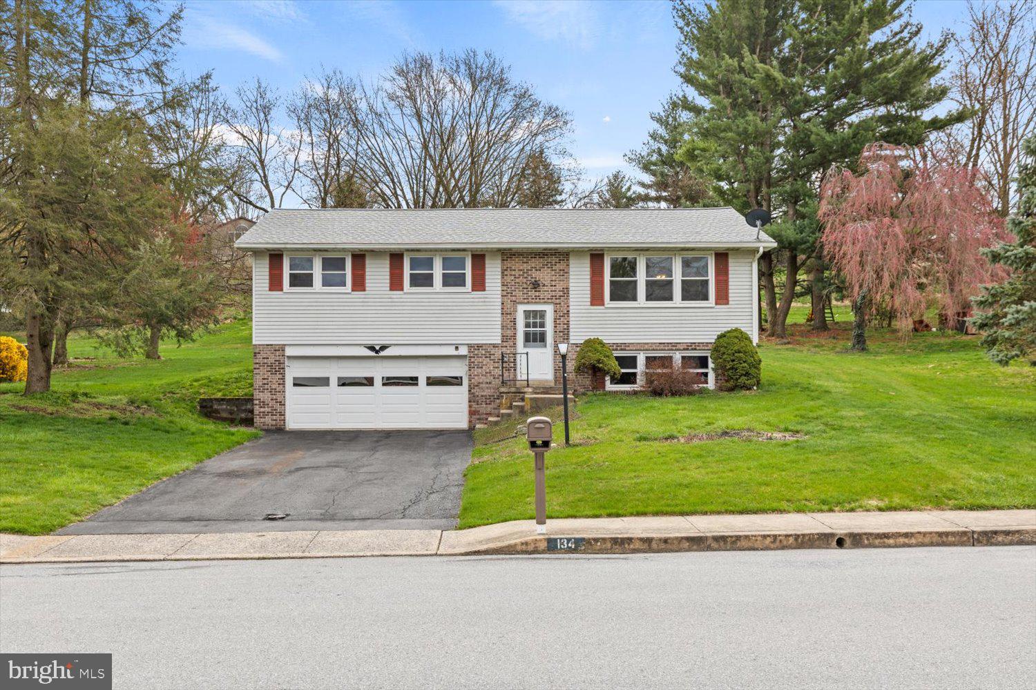 134 Bomberger Road Akron, PA 17501 - Photo 1 of 20 a front view of a house with a garden and trees