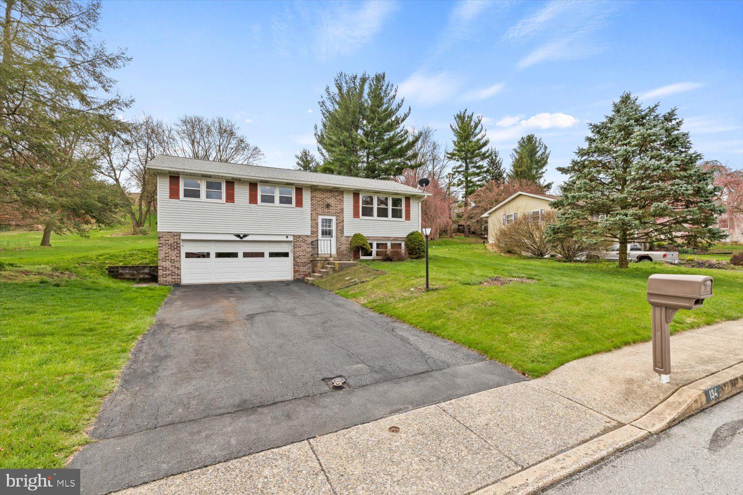 134 Bomberger Road Akron, PA 17501 - Photo 2 of 20 a front view of a house with a garden and trees