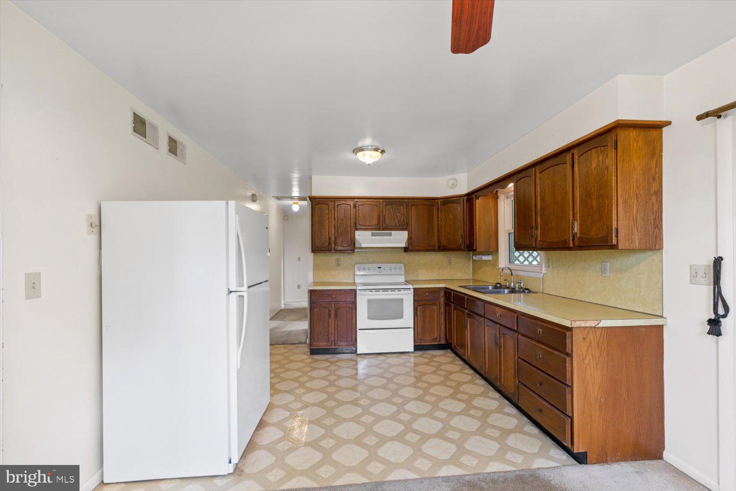 134 Bomberger Road Akron, PA 17501 - Photo 7 of 20 a kitchen with a refrigerator a stove top oven and cabinets