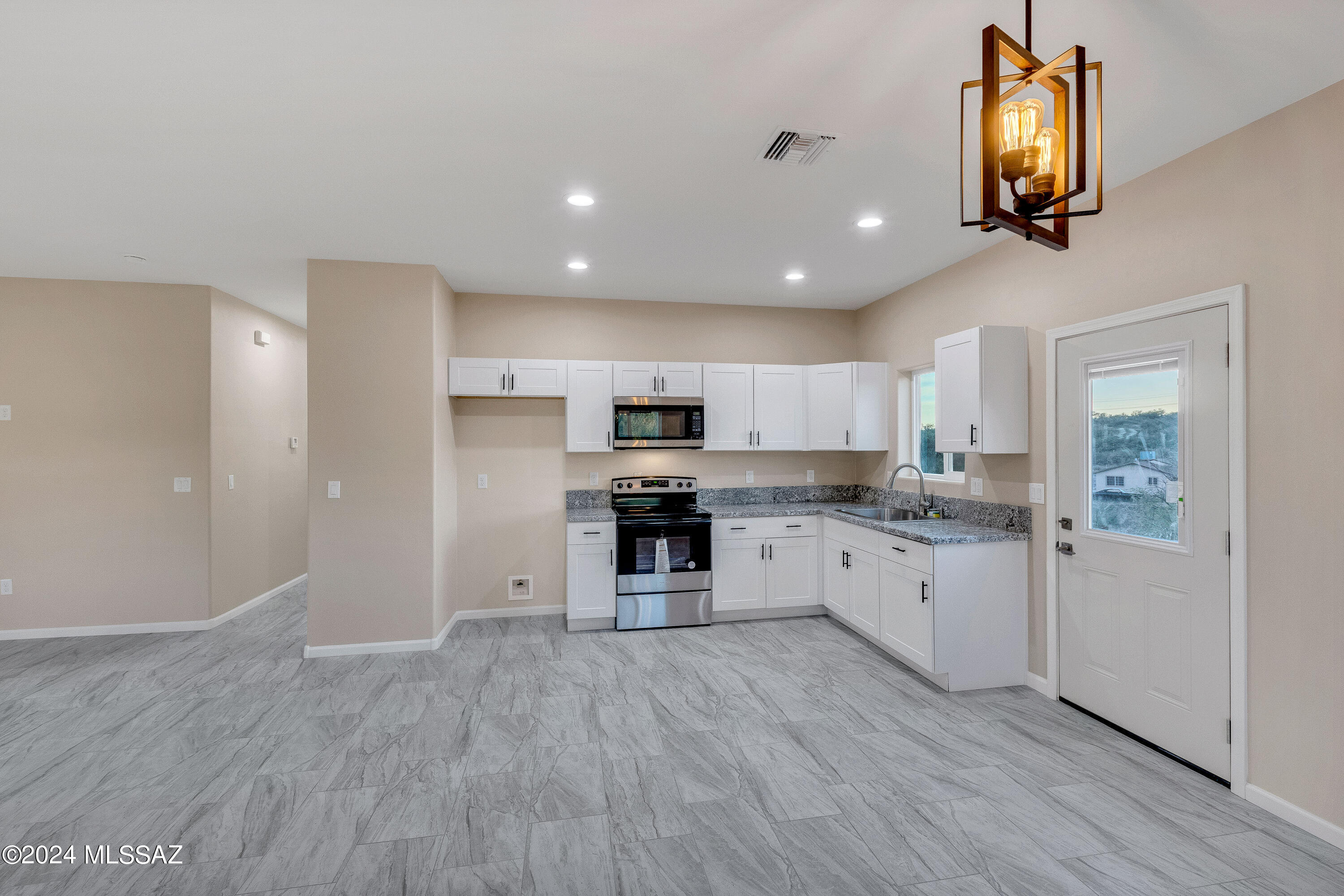 356 Globo Court Rio Rico, AZ 85648 - Photo 11 of 32 a large kitchen with cabinets wooden floor and stainless steel appliances