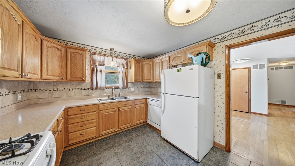 89 Dagg Road Parkersburg, WV 26101 - Photo 19 of 45 Kitchen featuring wood cabinetry, laminate countertops, tile backsplash, and tile flooring