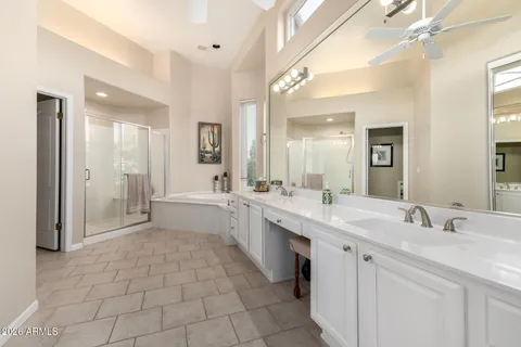 a large white bathroom with a granite countertop sink mirror and a bathtub