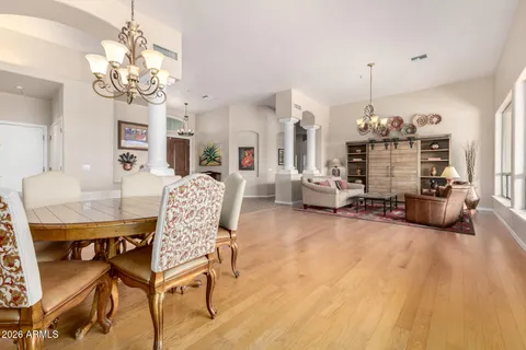 a view of a livingroom with furniture a chandelier and wooden floor