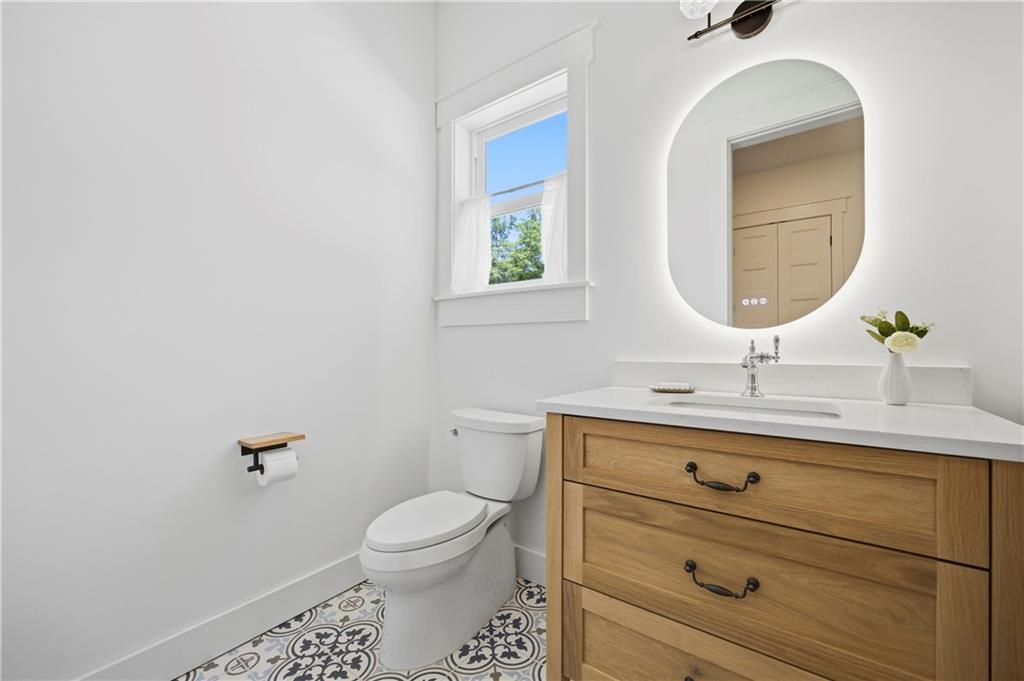 985 Whitehead Road Sugar Hill, GA 30518 - Photo 33 of 85 a bathroom with a toilet sink and mirror