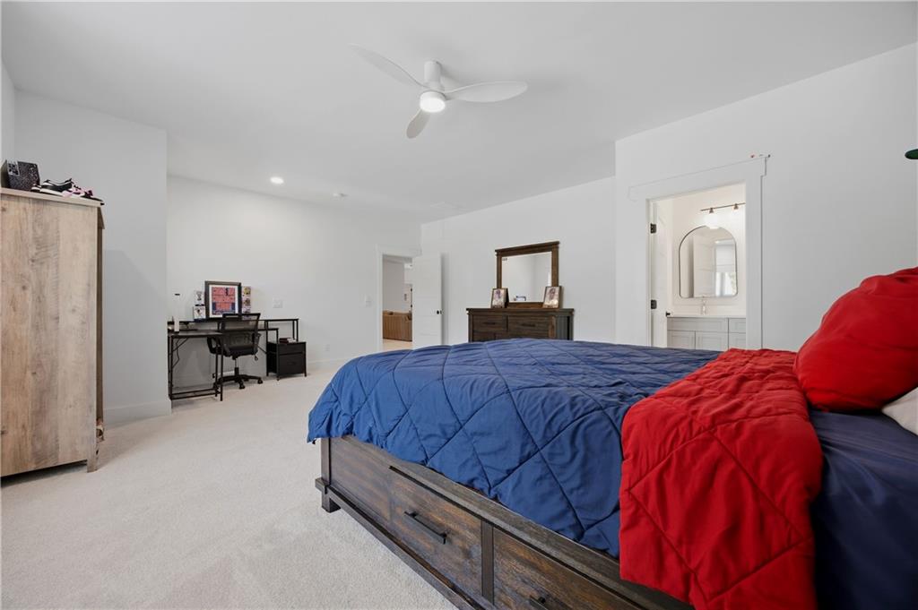 985 Whitehead Road Sugar Hill, GA 30518 - Photo 51 of 85 a bedroom with bed and a chandelier