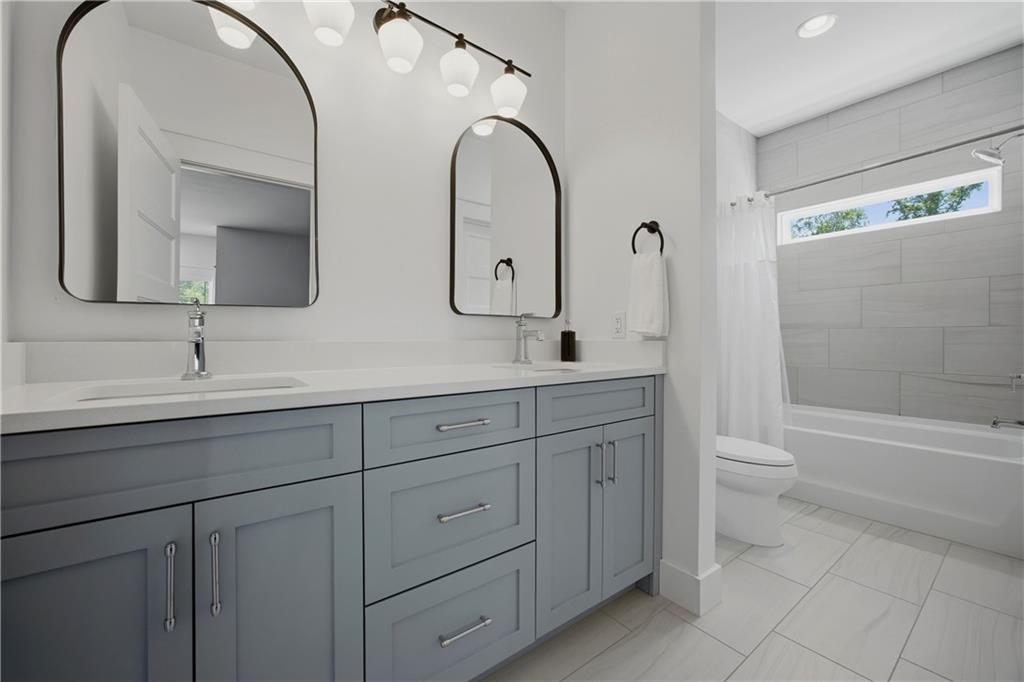 985 Whitehead Road Sugar Hill, GA 30518 - Photo 52 of 85 a spacious bathroom with a double vanity sink a toilet and a bathtub