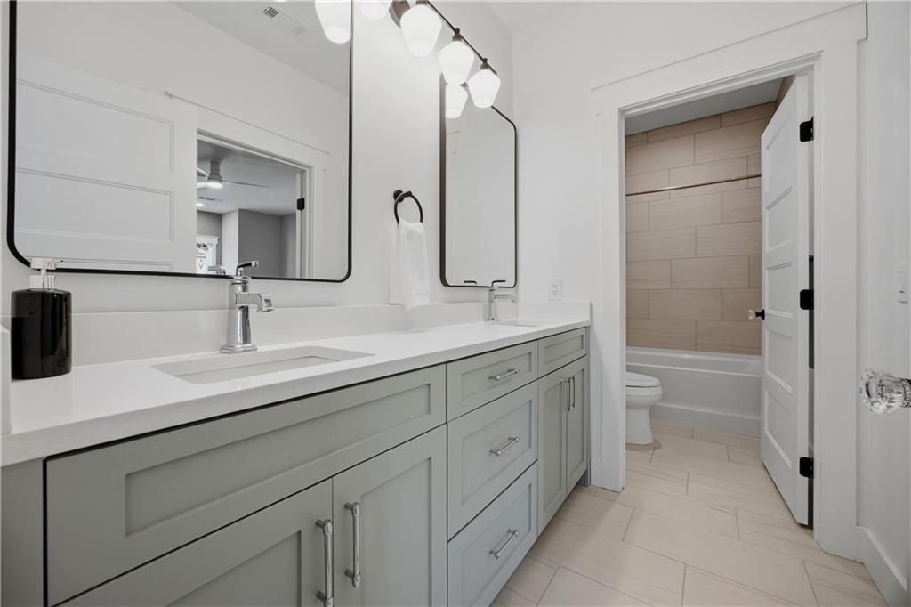 985 Whitehead Road Sugar Hill, GA 30518 - Photo 55 of 85 a bathroom with a double vanity sink mirror and bathtub