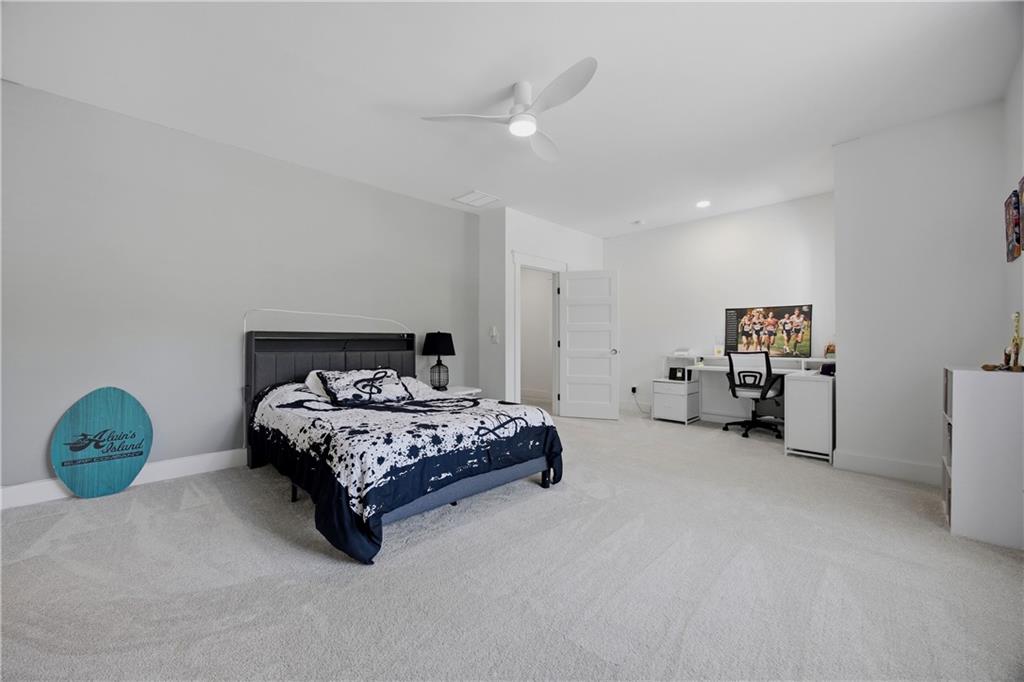 985 Whitehead Road Sugar Hill, GA 30518 - Photo 57 of 85 a bedroom with a bed and a chandelier