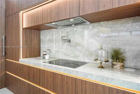 a kitchen with stainless steel appliances a large counter top a stove a chimney a sink and a large window