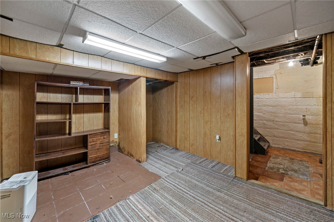 1589 Hampton Road Akron, OH 44305 - Photo 21 of 26 Finished basement featuring wood walls, a drop ceiling, and tile patterned floors