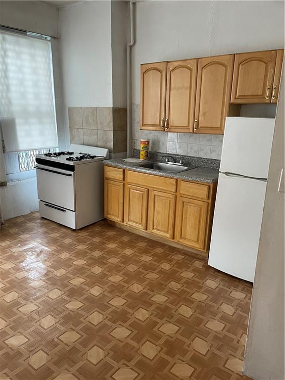 464 60th Street Brooklyn, NY 11220 - Photo 11 of 18 a kitchen with stainless steel appliances granite countertop a stove a sink and a refrigerator