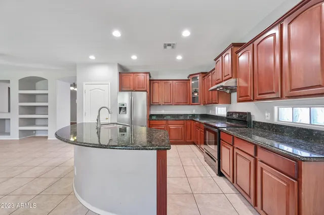 a kitchen with stainless steel appliances granite countertop a sink a stove and a granite counter tops