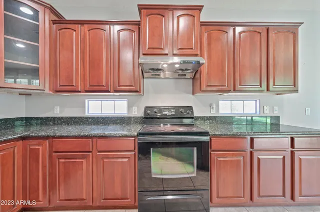 a kitchen with stainless steel appliances granite countertop a refrigerator and cabinets