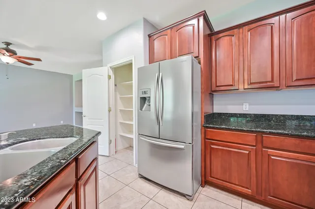 a kitchen with granite countertop stainless steel appliances a refrigerator stove top oven and sink