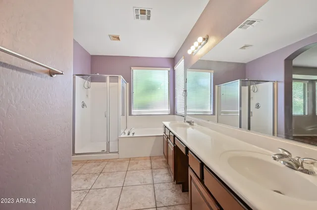 a spacious bathroom with a shower sink and mirror