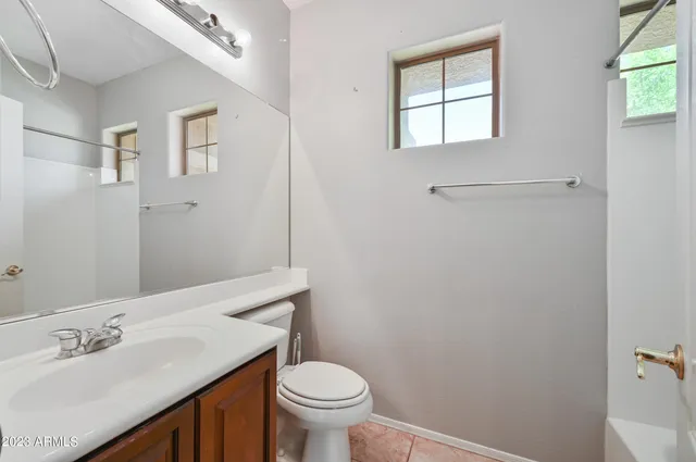 a bathroom with a sink toilet and window