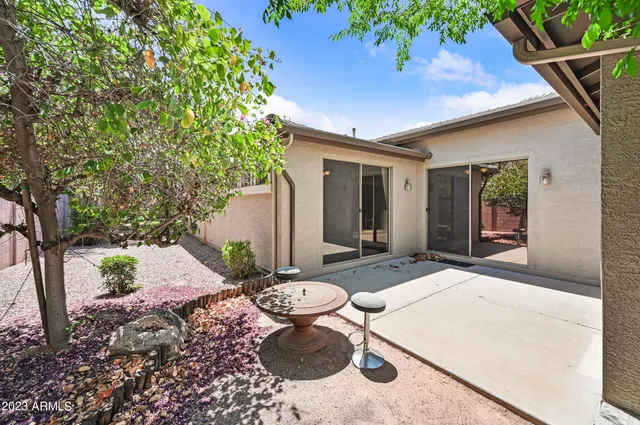 a backyard of a house with table and chairs