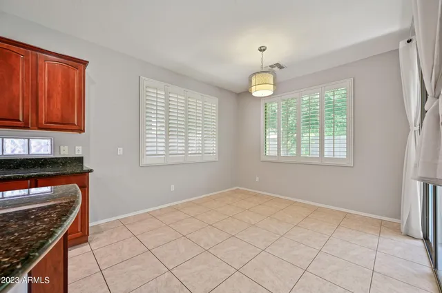 a view of an empty room with window and hardwood floor