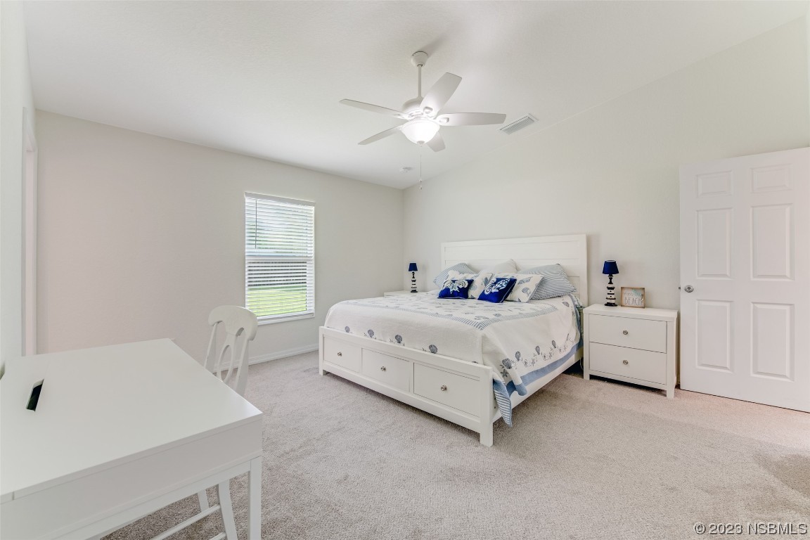 3129 Pine Tree Drive Edgewater, FL 32141 - Photo 14 of 34 a bed room with a bed and a chandelier
