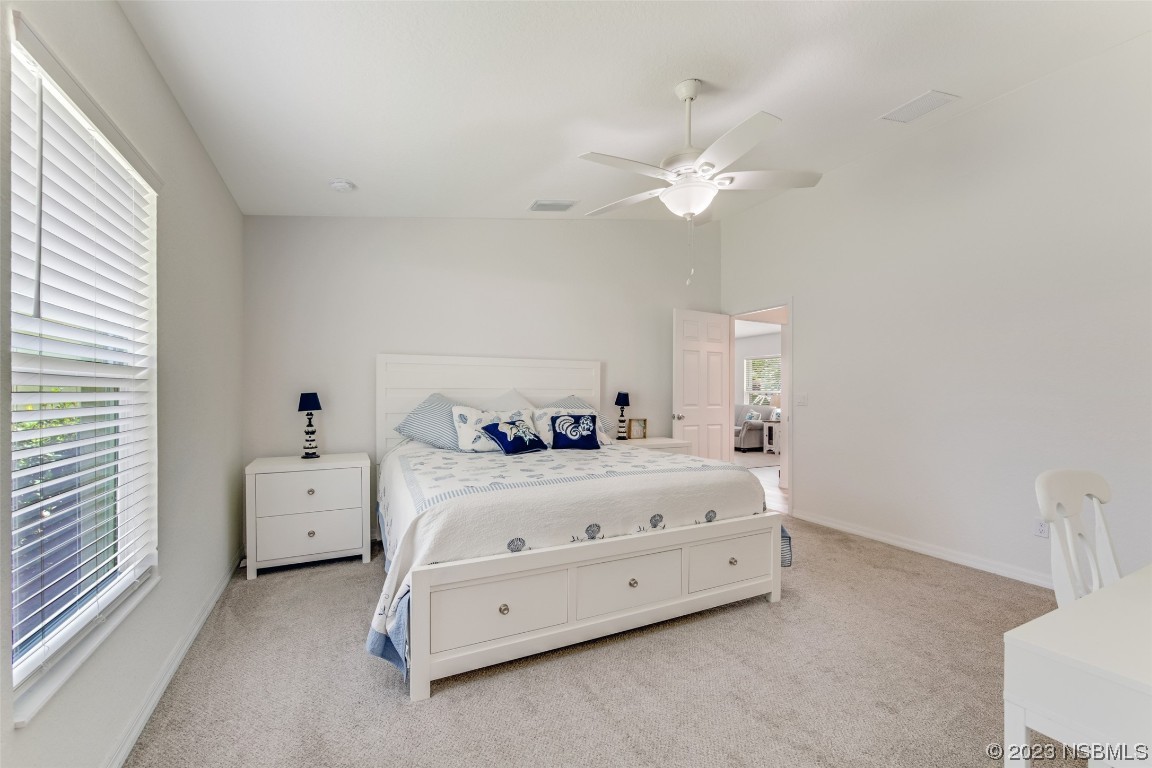3129 Pine Tree Drive Edgewater, FL 32141 - Photo 15 of 34 a room with a bed and a chandelier