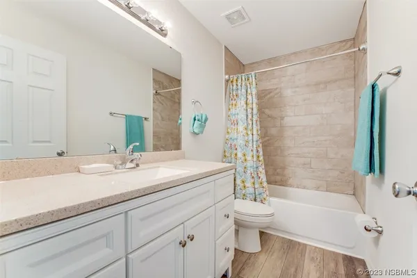 a bathroom with a granite countertop sink toilet tub and shower