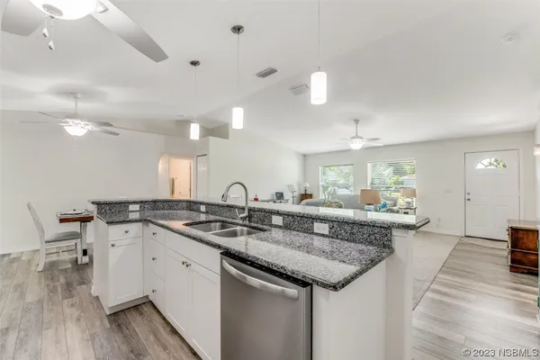 a kitchen with granite countertop a sink stainless steel appliances and cabinets