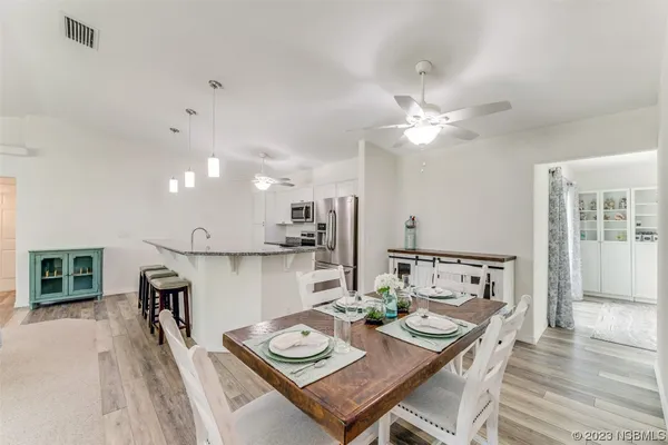 a view of a dining room with furniture and a chandelier