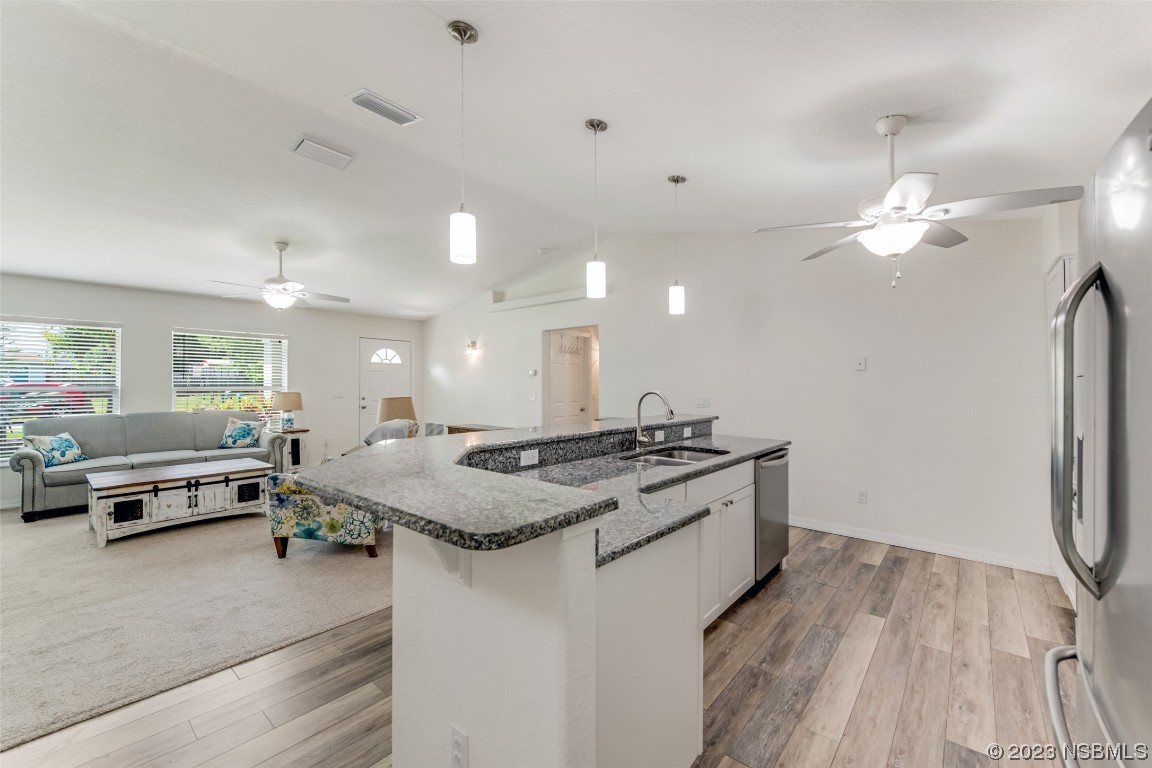 3129 Pine Tree Drive Edgewater, FL 32141 - Photo 10 of 34 a kitchen with stainless steel appliances granite countertop a stove and a refrigerator