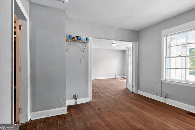 an empty room with wooden floor and a window