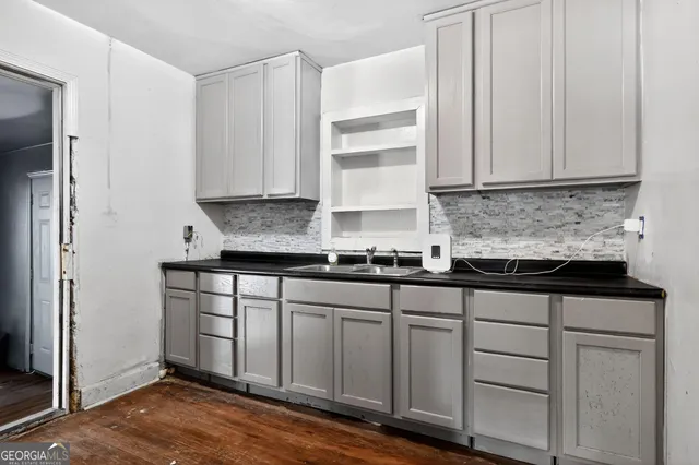 a kitchen with granite countertop white cabinets and sink