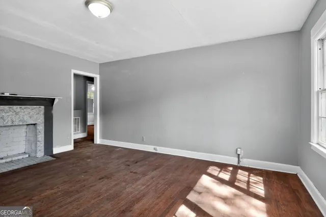 a view of a livingroom with wooden floor and a fireplace