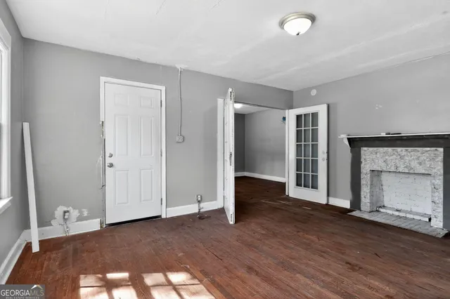 an empty room with wooden floor and a fireplace
