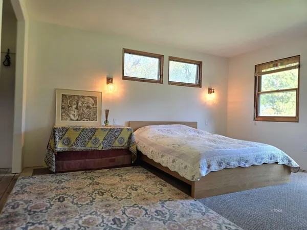 a bedroom with a bed and painting on the wall