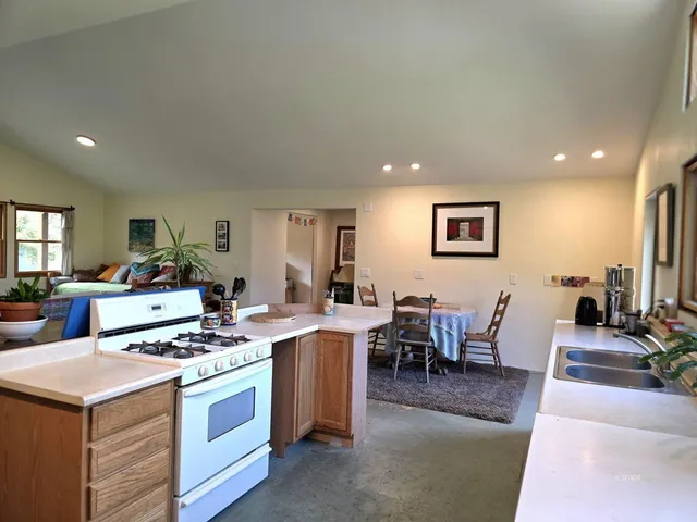 a living room with stainless steel appliances kitchen island granite countertop furniture a dining table and chairs