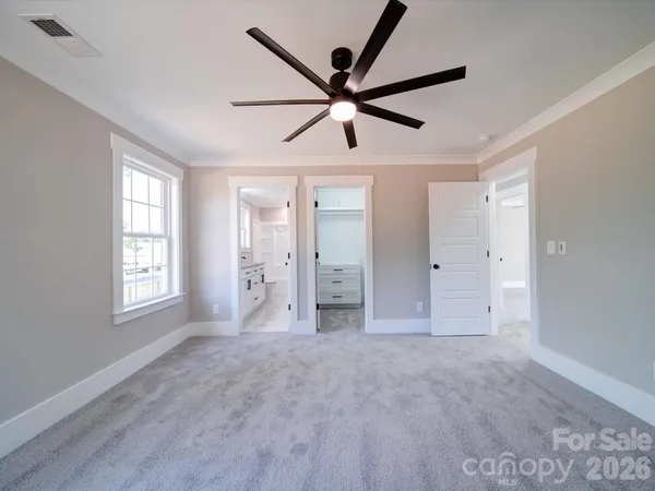 a view of empty room with window and ceiling fan