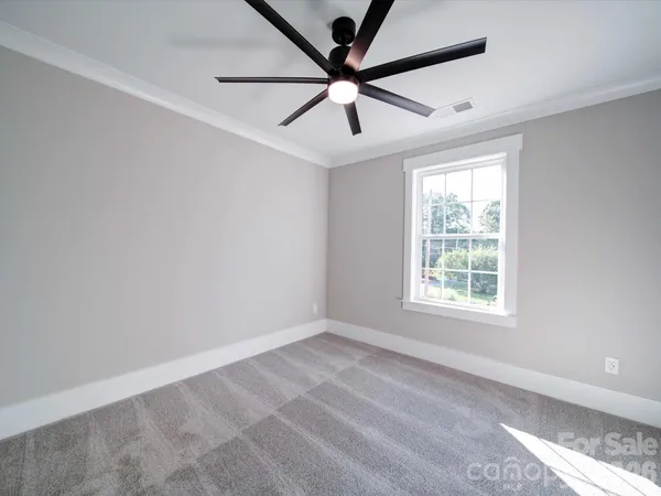 an empty room with a window and a fan
