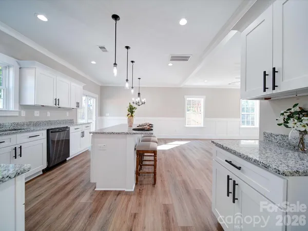 a kitchen with a sink a counter space wooden floor and stainless steel appliances