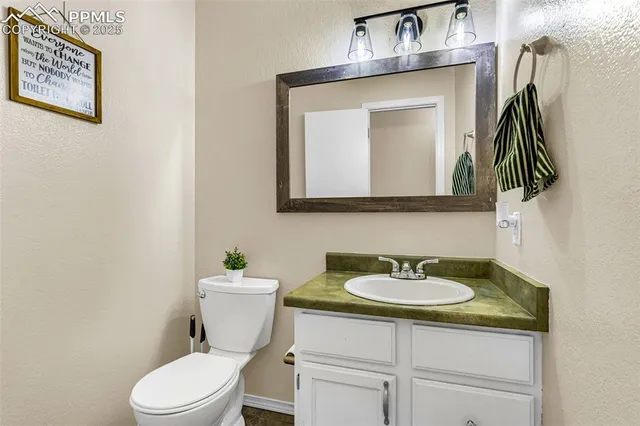 a bathroom with a toilet sink and mirror