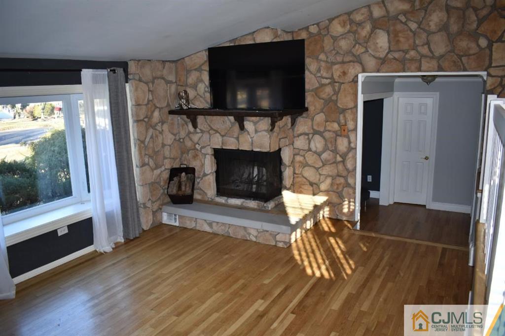 14 Timber Road East Brunswick, NJ 08816 - Photo 7 of 10 a living room with a fireplace and a flat screen tv