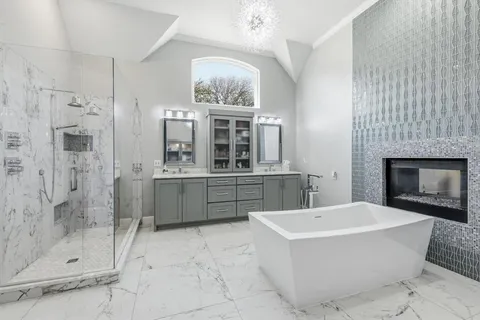 a bathroom with a tub sink shower and mirror