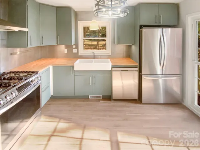 a kitchen with stainless steel appliances a stove a refrigerator and cabinets